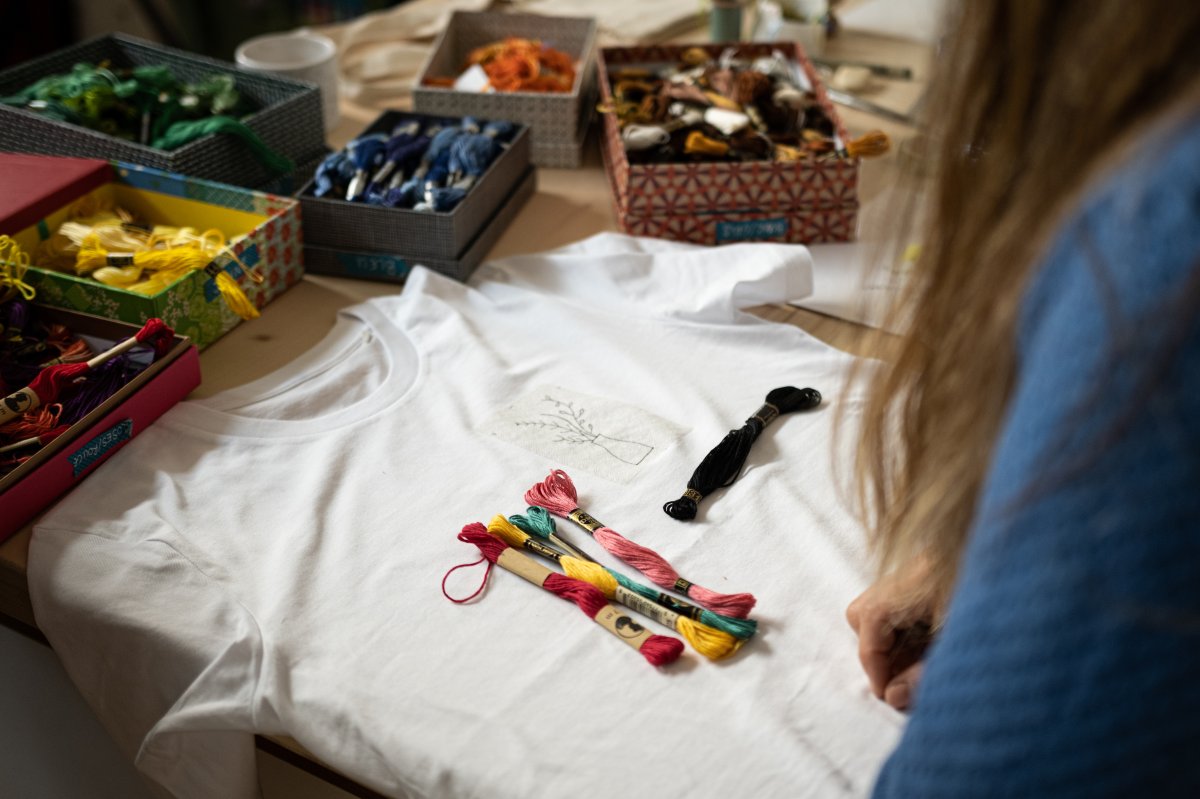 Broderie sur un t-shirt avec un grand choix de couleurs de fils de coton, pour broder un motif original sur un t-shirt en coton bio